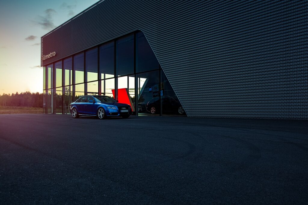 Blue Audi A4 Quattro Saloon Scene with Swedish modern architecture at dealership